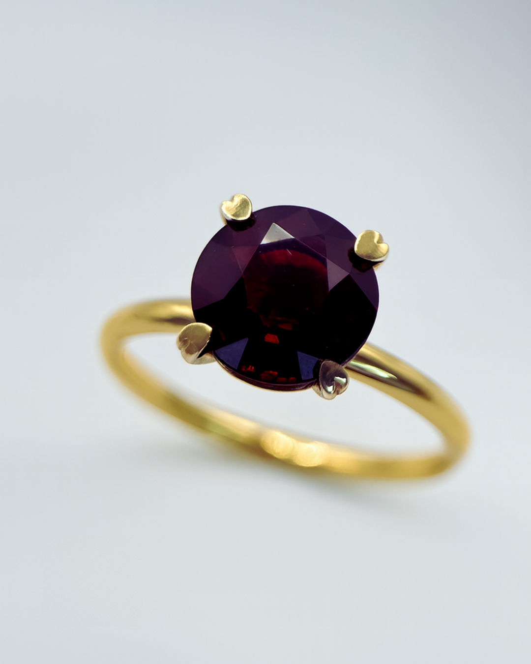 Geelgouden ring met granaat en hartjeszettingen