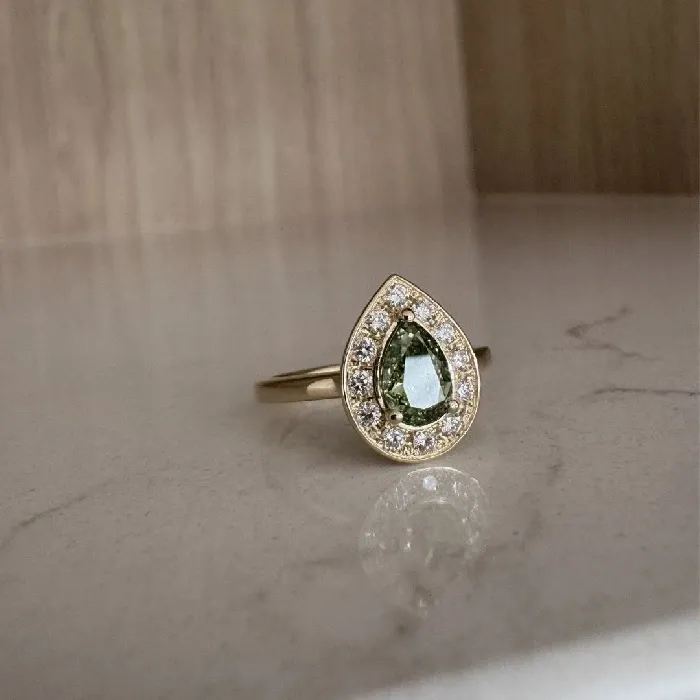 Ring met peervormige groene saffier en diamanten halo